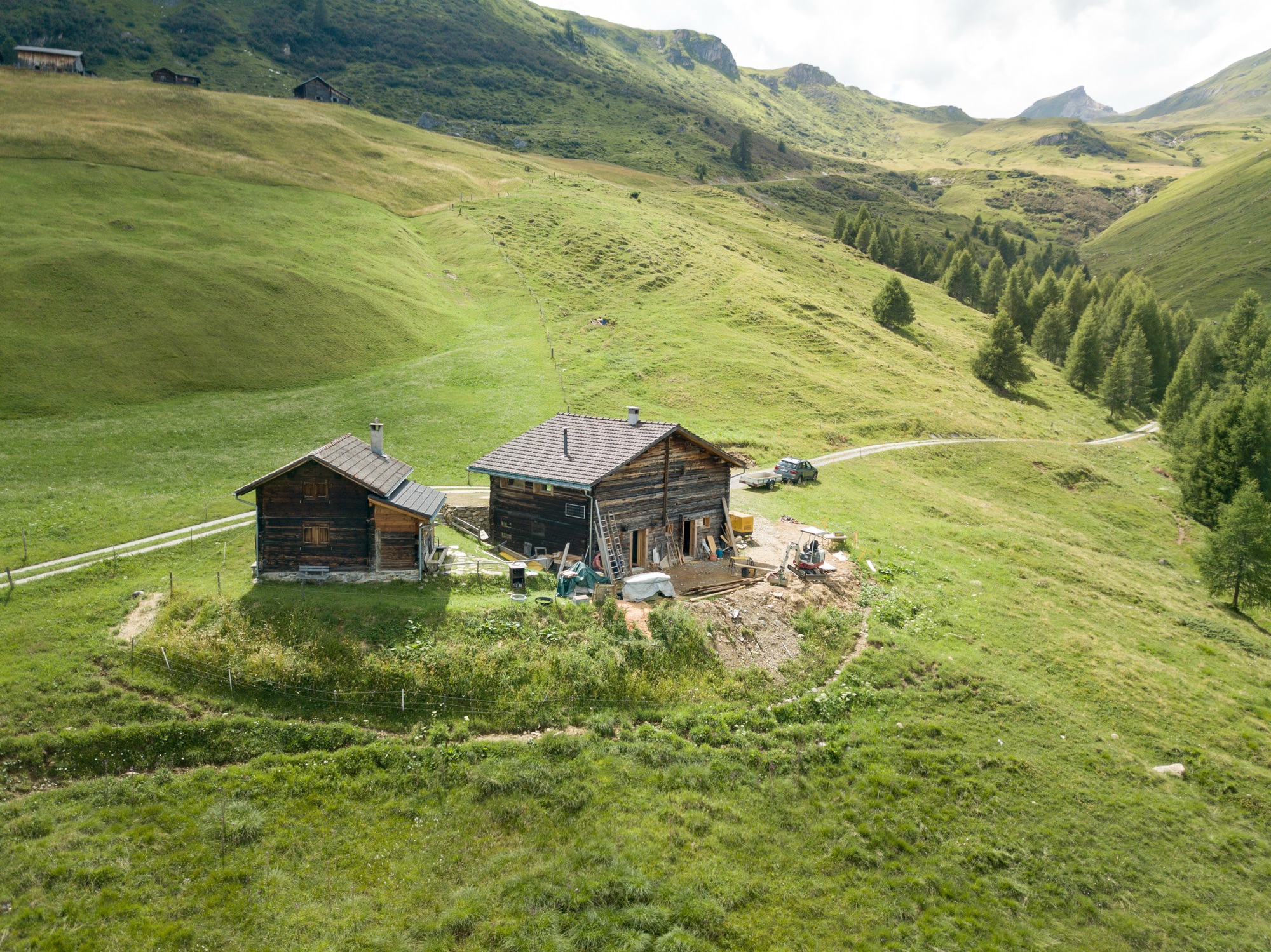 Luftaufnahme der Hütte inmitten grüner Alpwiesen