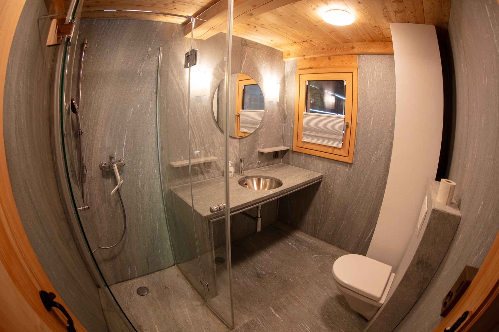Badezimmer mit Natursteindusche und Waschbecken