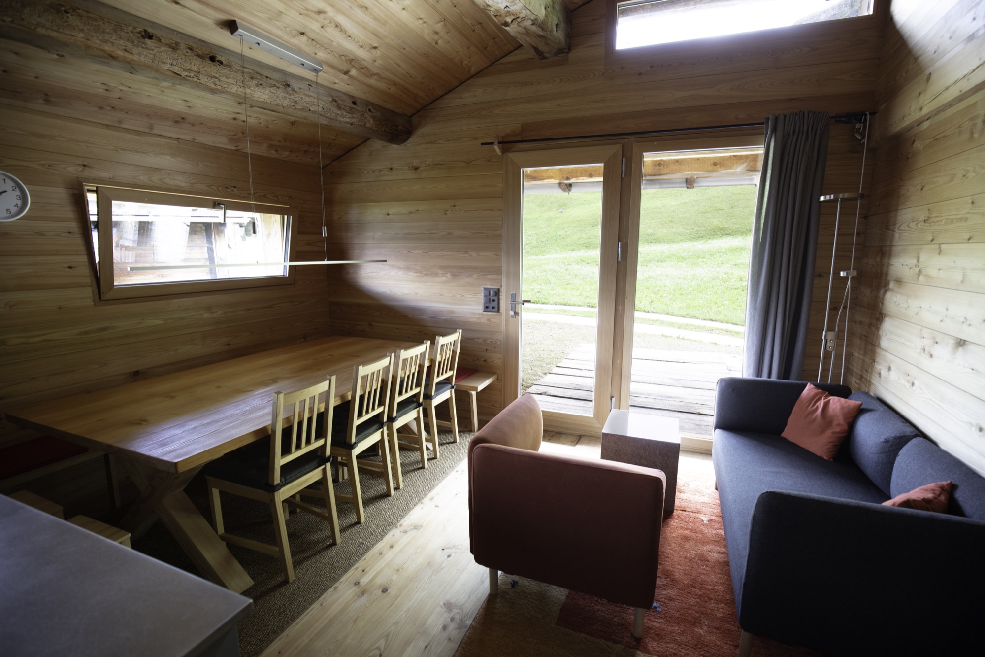 Essbereich mit langem Holztisch und Blick auf die Wiese